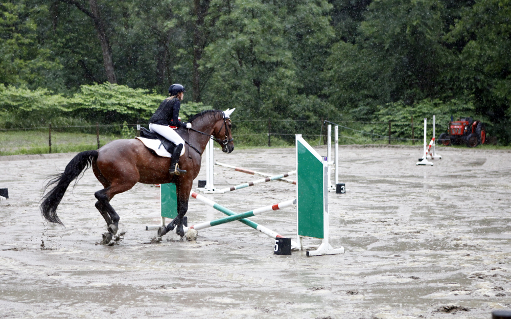 salto ostacoli equitazione sotto la pioggia
